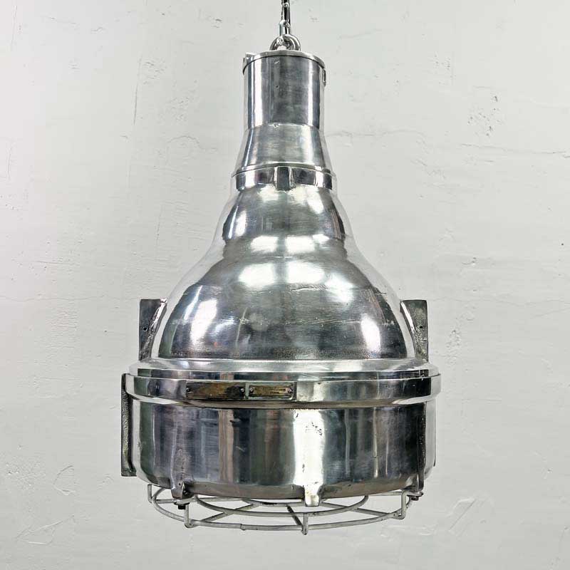 The large explosion proof cast aluminium pendant light was made by the Indian company Baliga Lighting Equipments Ltd. It is a very heavy solid metal light fixture which features a cage over the tempered glass lens that protects the lamp holder from external elements.&nbsp;