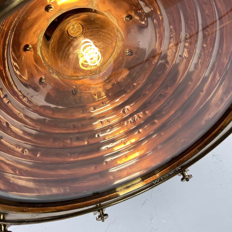 This is a large vintage industrial copper and brass industrial cargo ceiling light made by the German manufacturer Wiska. It consists of a fluted spun copper dome with cast brass top section . It has wing nuts on the hanging mount so that the light can be tilted and illumination directional.