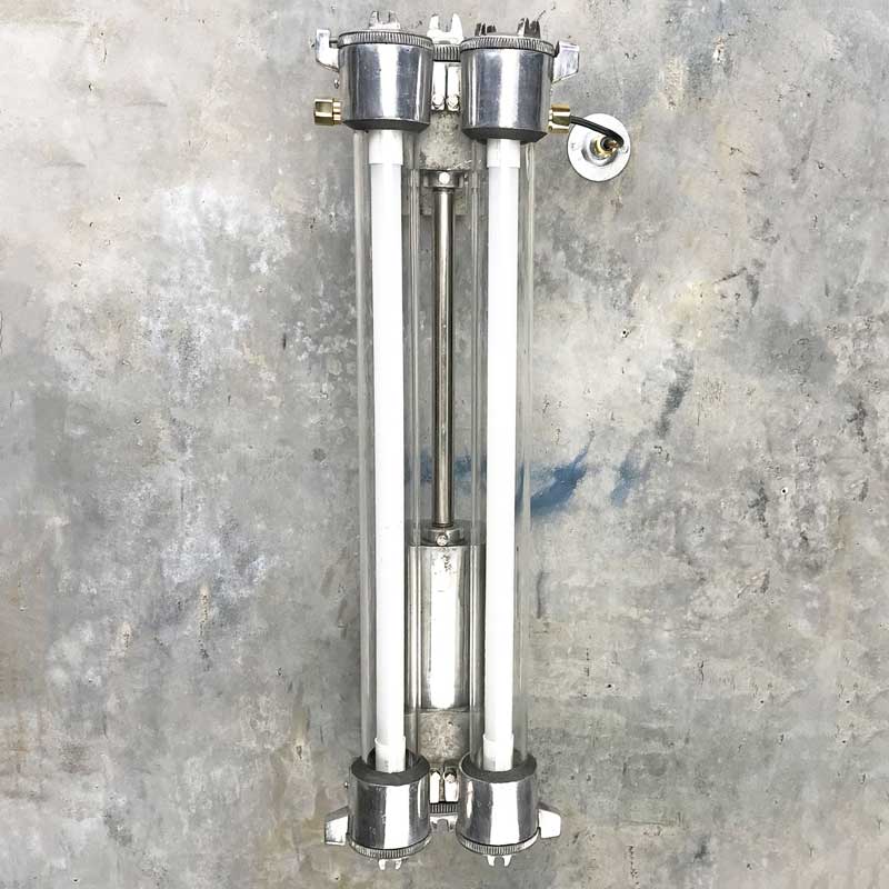 A vintage industrial twin T8 flameproof wall strip light, restored for modern interiors. An industrial style wall light with an aluminium body & flameproof glass tubes. 